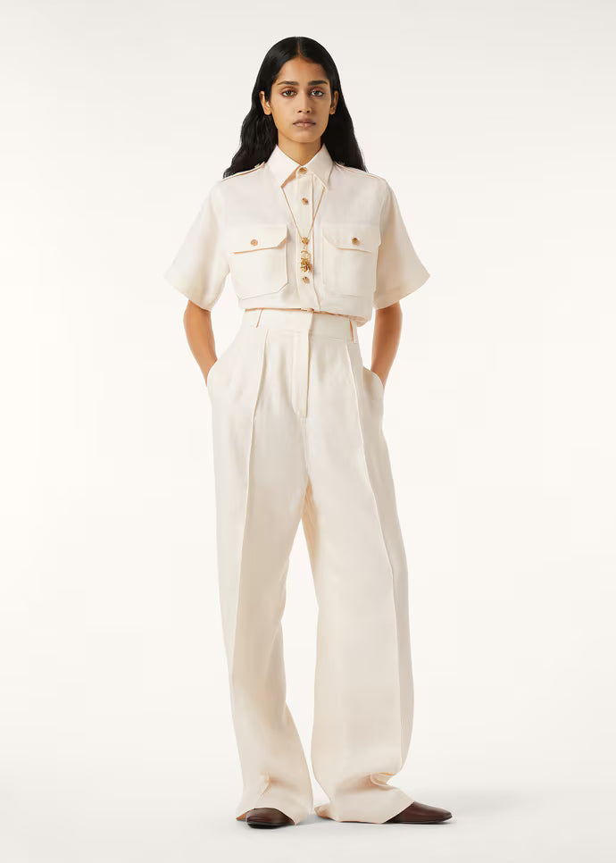 Model wearing a cream cropped shirt and wide-leg trousers