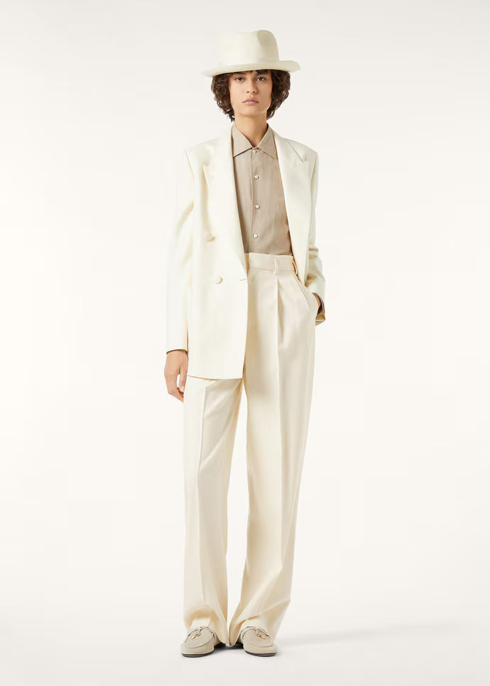 Model wearing a cream double-breasted suit with a wide-brim hat
